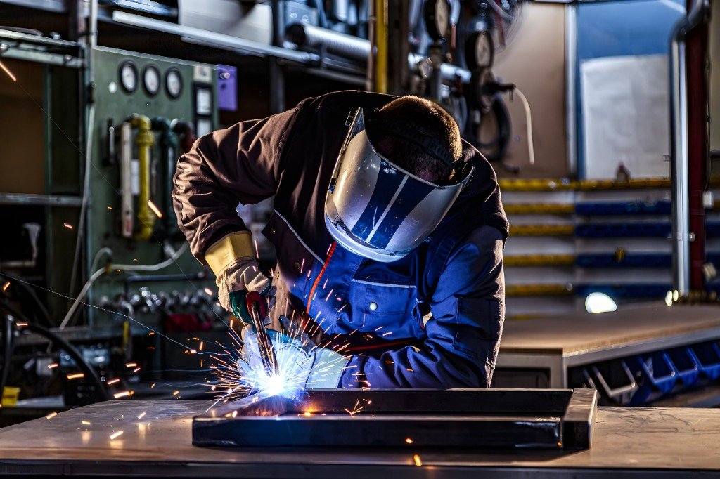 Mechanical engineers and certified pipe welders in clean technical gear working on refinery turnaround